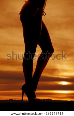 A woman legs in a bikini in the sunset.