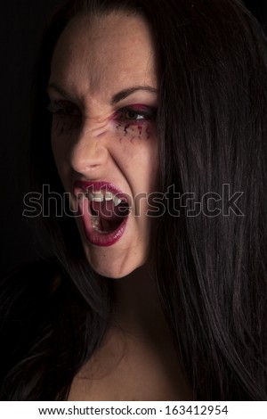 a woman vampire looking with her mouth open and a fierce expression on her face.