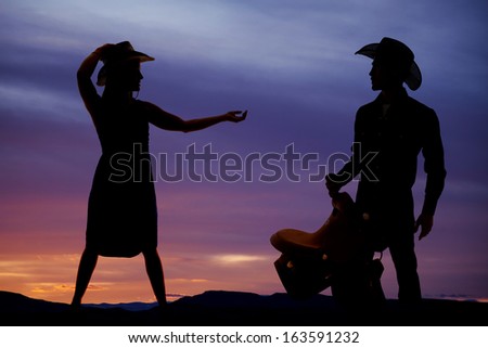 a silhouette of a woman reaching out her hand to the cowboy in the picture.