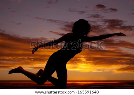 A silhouette of a woman kneeling and reaching out.