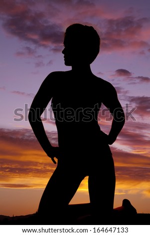 A silhouette of a woman kneeling with her hands on her hips.