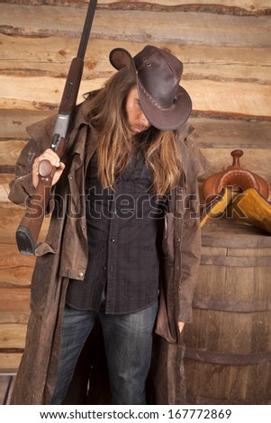 A cowboy holding on to his weapon with his head down.