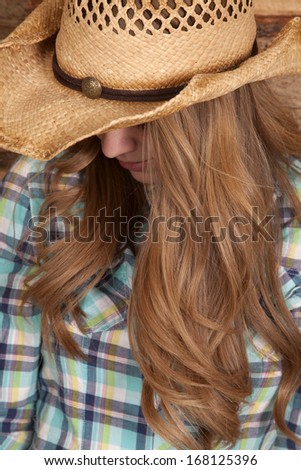 a cowgirl looking down so you can not see her face