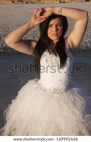 A woman with her arms up above her head standing on a frozen lake.