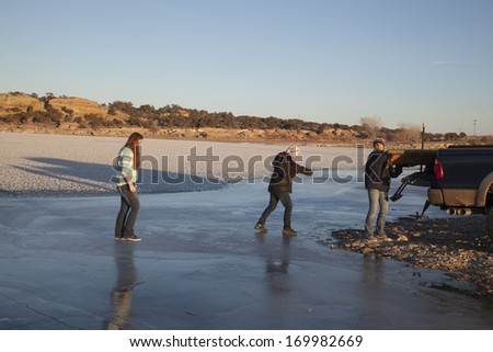 Three woman walking on ice trying not to fall.