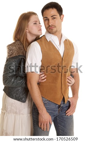 A woman in a leather jacket is looking at a man in a brown vest.