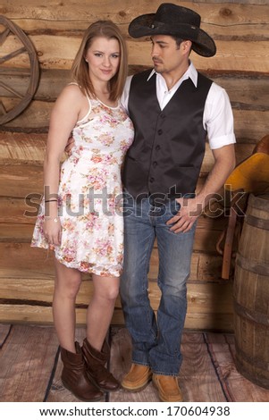 A woman is smiling while standing next to her cowboy.