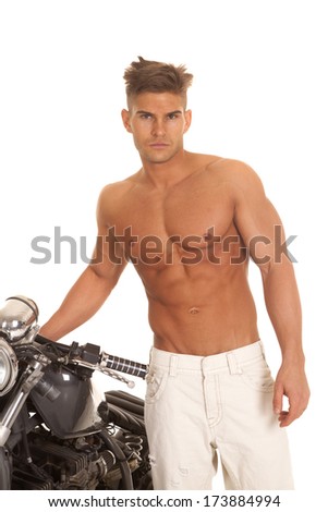 a man without a shirt on standing by the motorcycle.