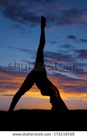 A silhouette of a woman dancing in the sunset.