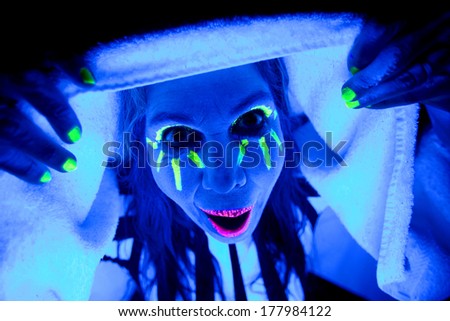 A woman glowing like a ghost with a towel over her head.