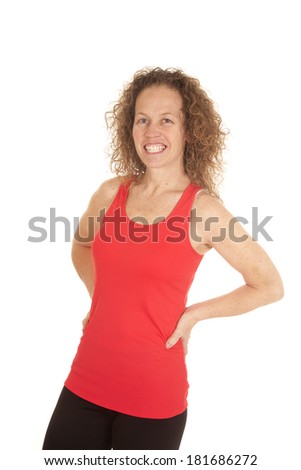 a woman in her fitness clothing with a smile on her face standing.