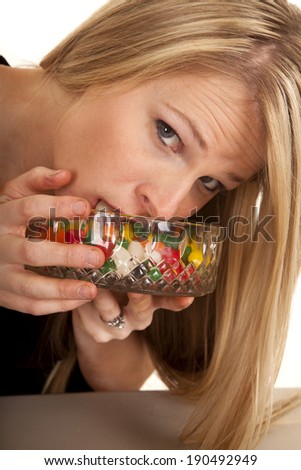 A woman putting her face in to the jelly bean bowl.