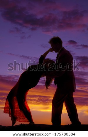 a silhouette of a woman leaning back touching her man\'s face