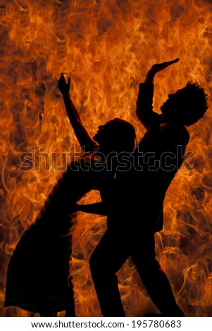 A silhouette of a woman leaning back on a man with fire.