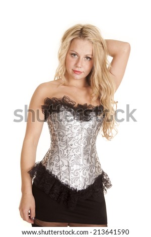 A woman in her silver and black corset and short black skirt with a sensual expression on her face.
