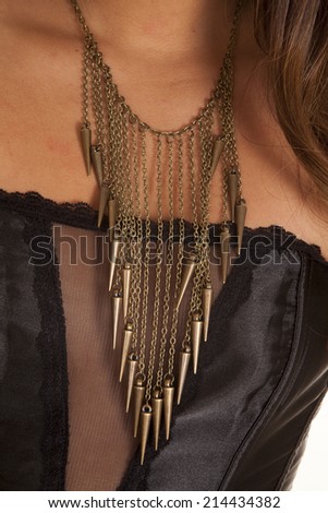 A close up of a woman\'s neck wearing a gold charm necklace.