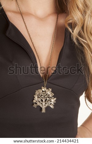 A woman wearing a necklace with a tree charm.