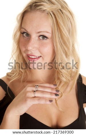 A woman with a smile on her face, showing off the rings on her fingers.