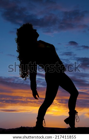 a silhouette of a woman leaning back, letting her hair fall back