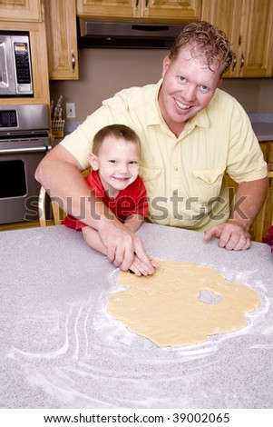 A father and son making cut out cookies.