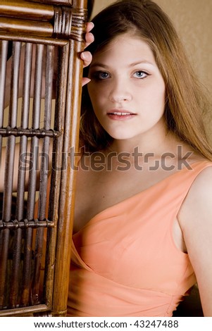 a close up of a woman in her peach formal with a sensual look on her face.