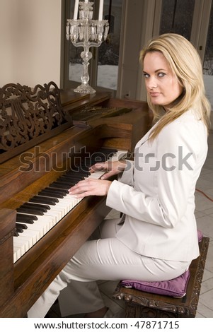 A woman sitting at the piano playing and looking with a serious expression on her face.