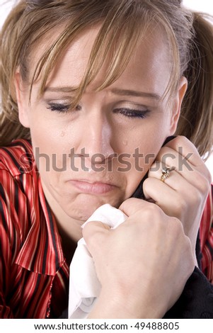 A woman who is sick and tired with a sad expression on her face with tears coming from her eyes and a runny nose.