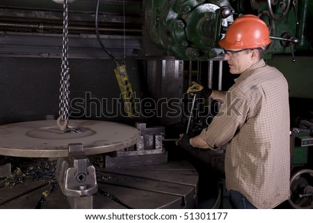 A man making sure his part is tight in the machine.