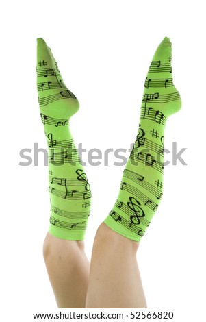 Womans legs up in the air with green socks and music notes on them.