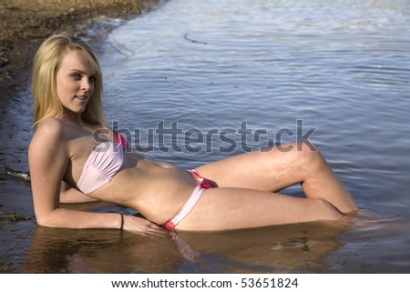 A woman relaxing and cooling off in the nice water by the beach.
