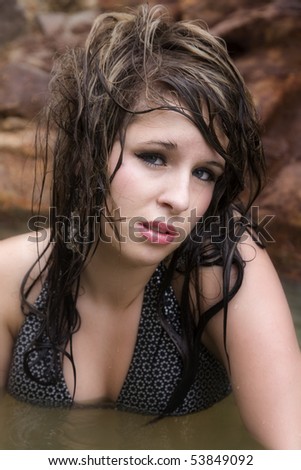 A beautiful woman in the water with wet hair.