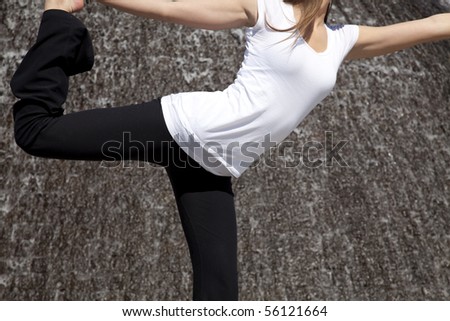 a close up of a woman doing a yoga pose with water in the background.