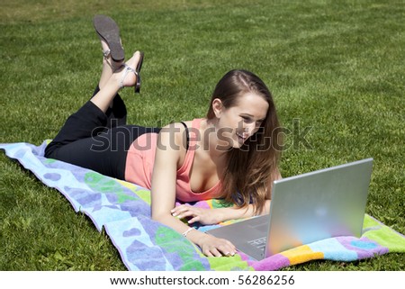 A woman looking at something on her computer laughing at a story.