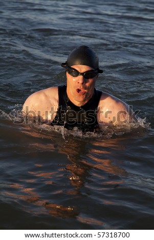 A man in a wet suit swimming.