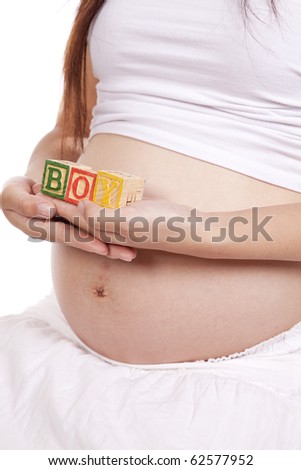 A pregnant woman holding blocks that spell boy