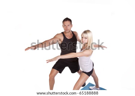 a couple training and doing yoga stretches together with serious expressions on their faces.
