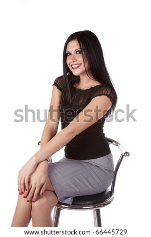 a business woman sitting on a bar stool with her hands on her knees with a big smile on her face.
