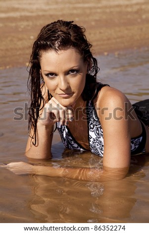 a woman laying in the water with  a serious expression on her face.