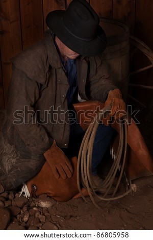 A man kneeling down by a wine barrel looking for something.