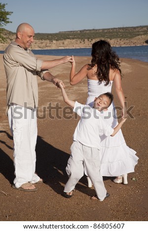 A family dancing around on the beach.