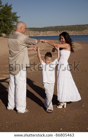 A family dancing and playing on the beach.