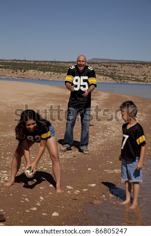 a family laughing and having fun playing football.