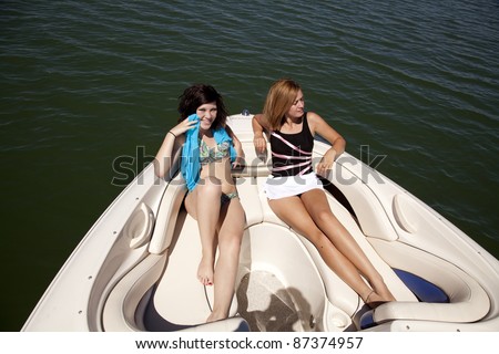 Two women sitting on a boat relaxing and enjoying the warmth of the sun.