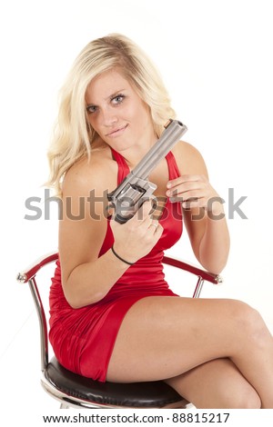 A woman in her red dress holding on to a gun with  an evil expression on her face.