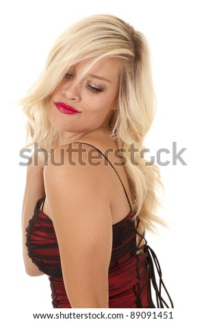 A woman in her fancy red dress looking down with a sensual expression on her face.