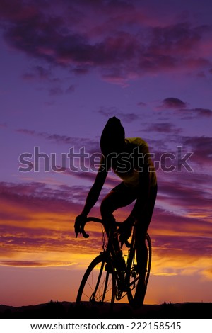 A silhouette of a  man on his mountain bike riding in the outdoors.