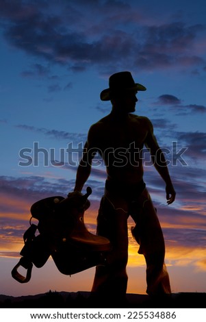 A silhouette of a cowboy looking to the side, holding on to his saddle.