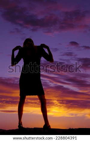 A silhouette of a woman with her head back and her hands on her shoulders