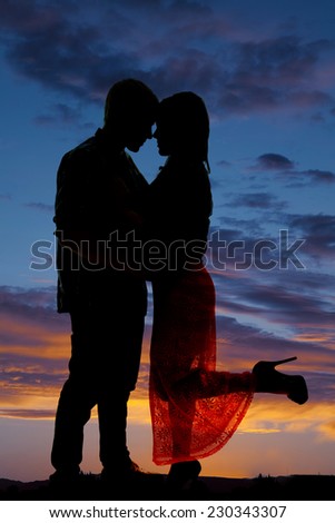 a silhouette of a woman kicking up her leg, as she cuddles with her man.
