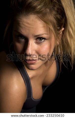 A woman in her black sports bra, sweating after a work out